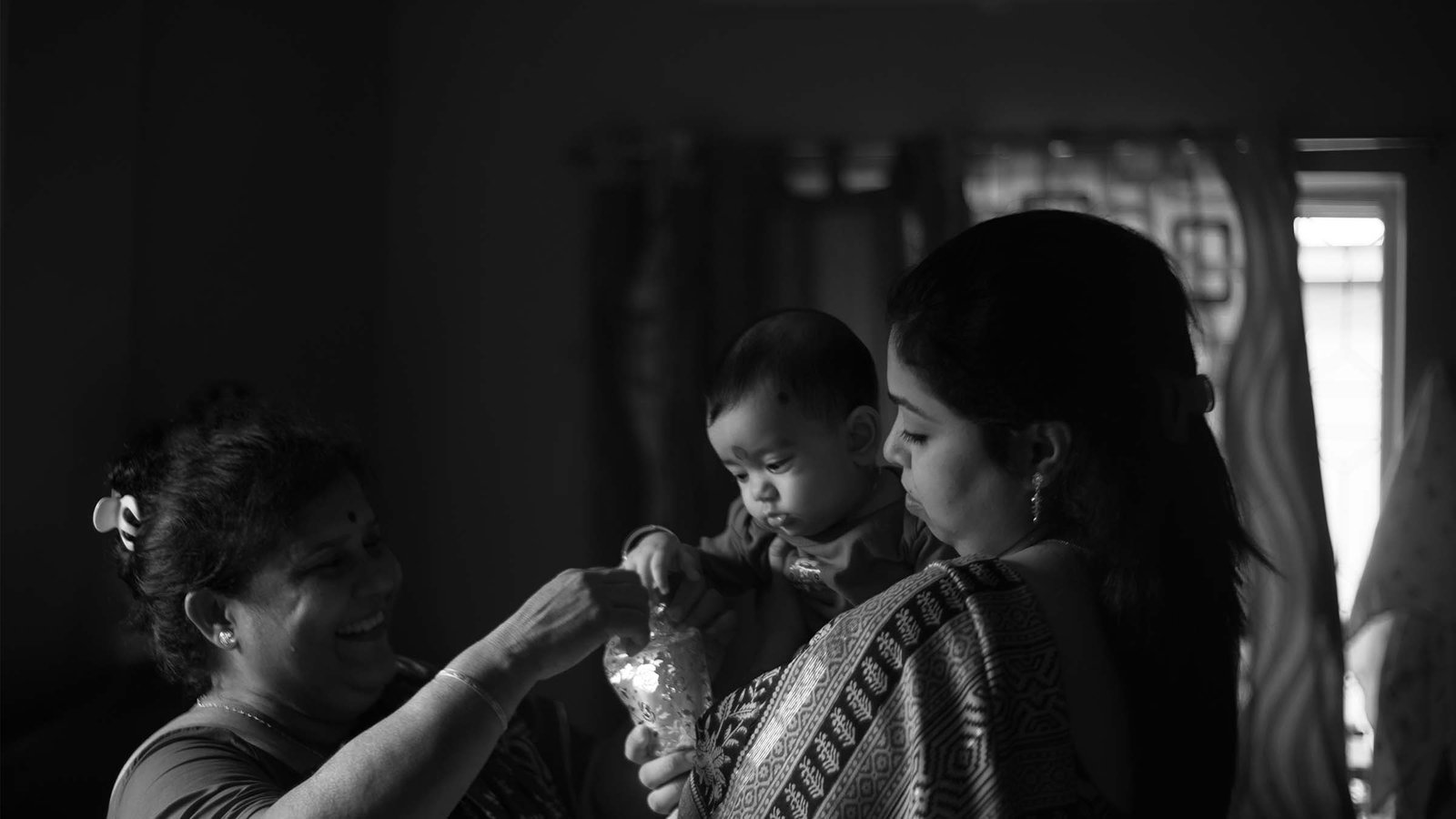 Maternal uncle feeding baby rice — sacred Annaprashan moment